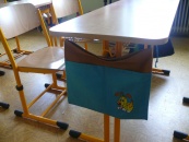 Kapsář se štěnětem zavěšený na lavici